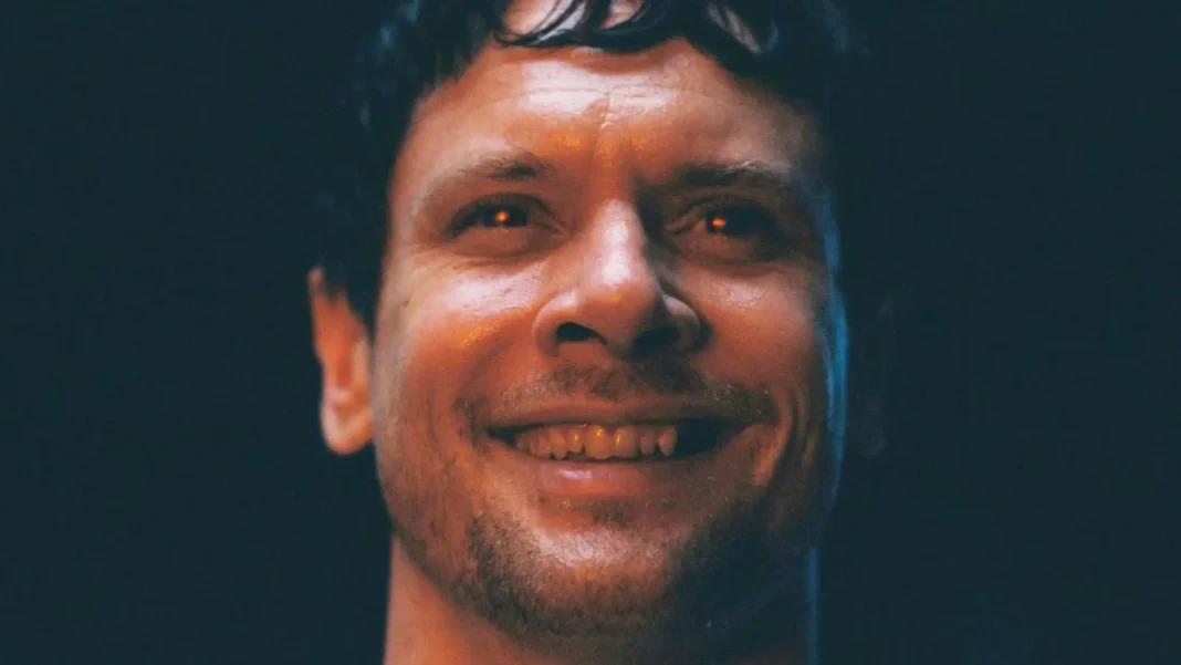 remmick-smiling-while-his-eyes-glow-red-in-sinners I Peccatori